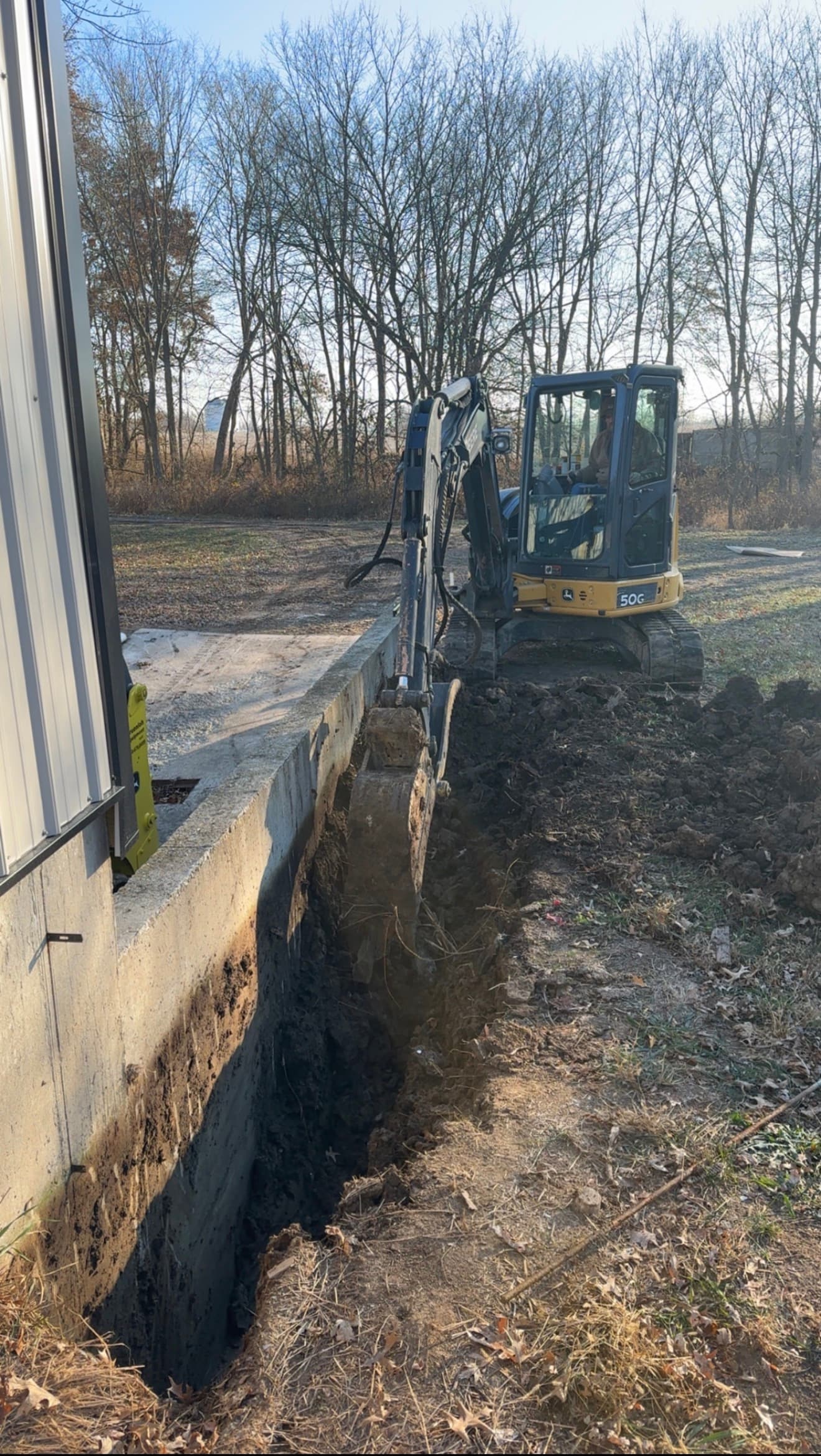 John Deere mini excavator digging a foundation trench in Missouri