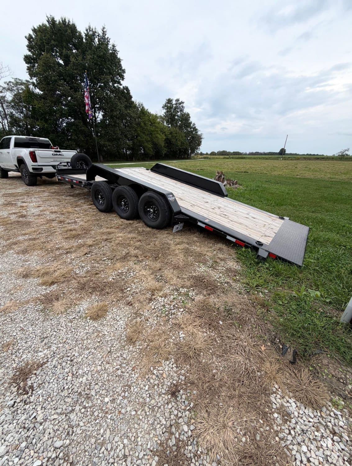 Tilt deck trailer tilted down for loading equipment, available for rent in Macon County, Missouri
